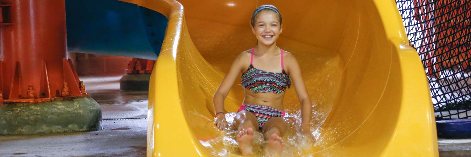 Girl on a water slide at Buccaneer Bay, the Indoor water park at Honey Creek Resort