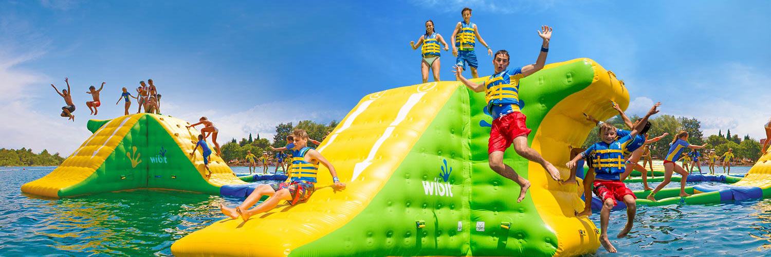 Kids play in an aquapark inflatable waterpark on a lake