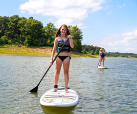 People enjoy fun activities like stand up paddleboarding on Rathbun Lake