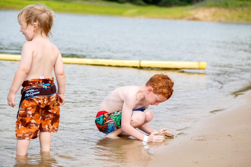 Kids play along the Rathbun Lake shoreline at Honey Creek Resort