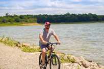 A man bikes on a trail near Rathbun Lake at Honey Creek Resort