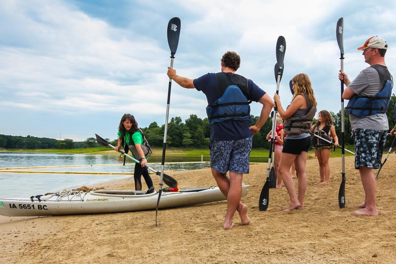 A group of friends participate in a kayak class along Rathbun Lake at Honey Creek Resort