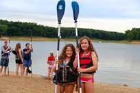 Girls get ready to go stand-up paddleboarding on Rathbun Lake at Honey Creek Resort