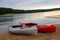 Kayak rentals from Honey Creek Resort are placed near the Rathbun Lake shoreline