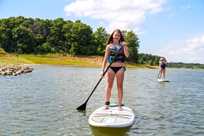 Girls enjoy stand-up paddleboarding on Rathbun Lake with SUP rentals from Honey Creek Resort