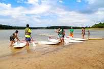 A group of friends receive instruction on how to use stand up paddleboards on Rathbun Lake