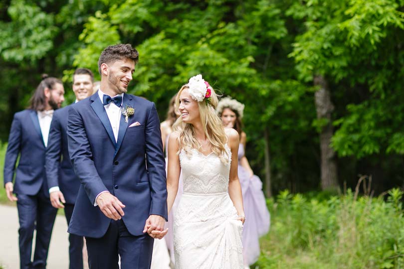 Wedding party celebrates the bride & groom on the lawn at Honey Creek Resort in Iowa