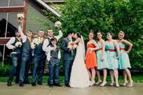 The groomsmen hold the bouquets in this fun wedding party photo at Honey Creek Resort