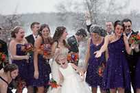Winter wedding bridal party taking pictures in the snow at Honey Creek Resort
