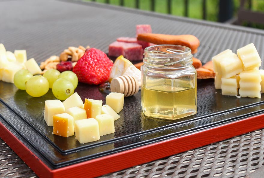 Fruit, cheese, and honey are served on a tray at Honey Creek Resort
