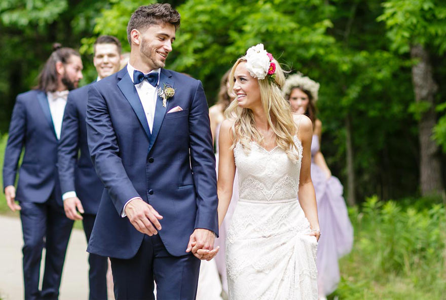 Happy newlyweds walk hand-in-hand after their wedding ceremony at Honey Creek Resort