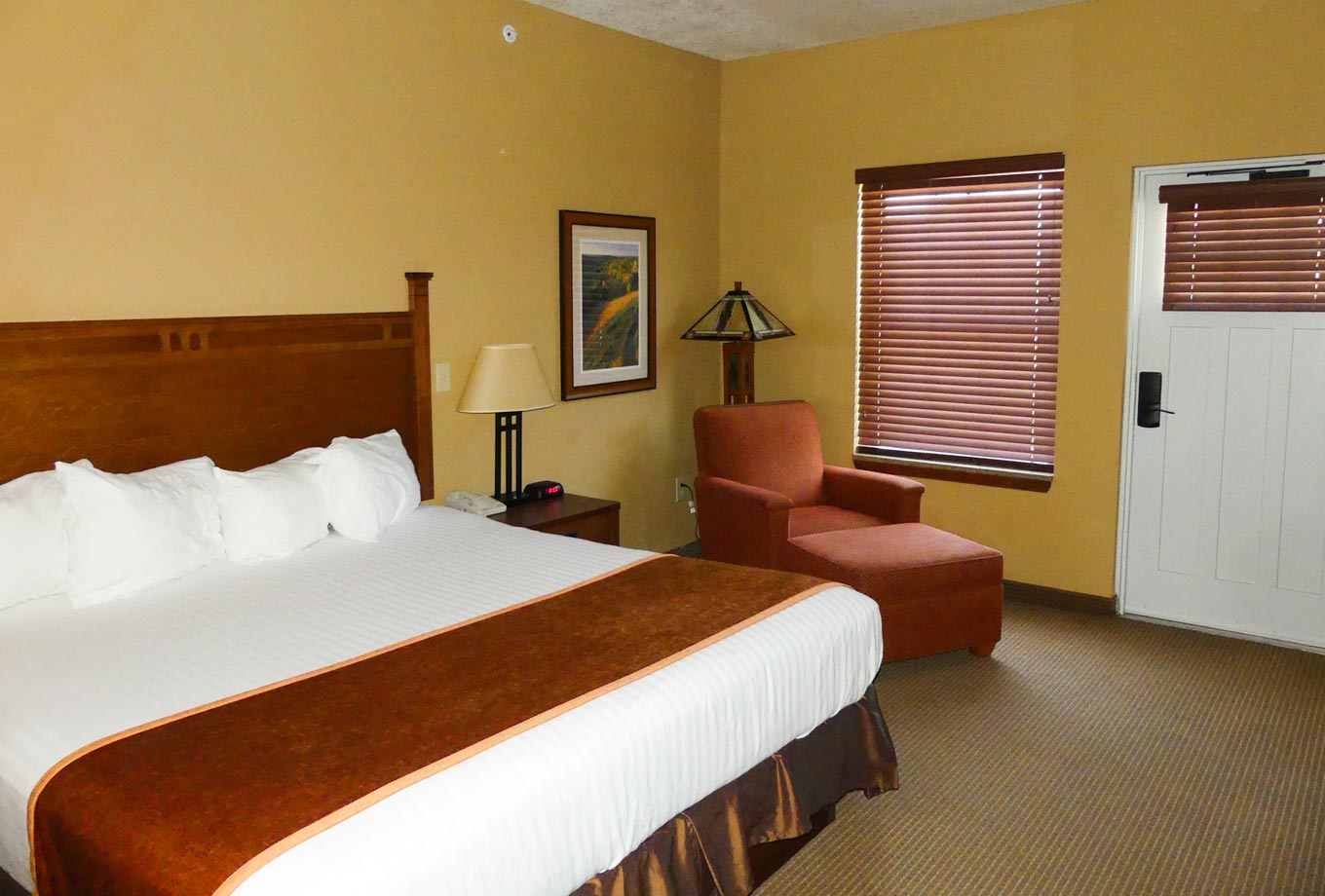 A king-size bed is featured in a guest room at Honey Creek Resort's the Lodge on Rathbun Lake