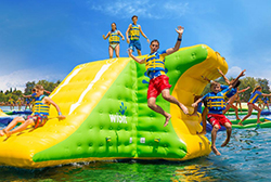 Kids play in an aquapark inflatable waterpark on a lake