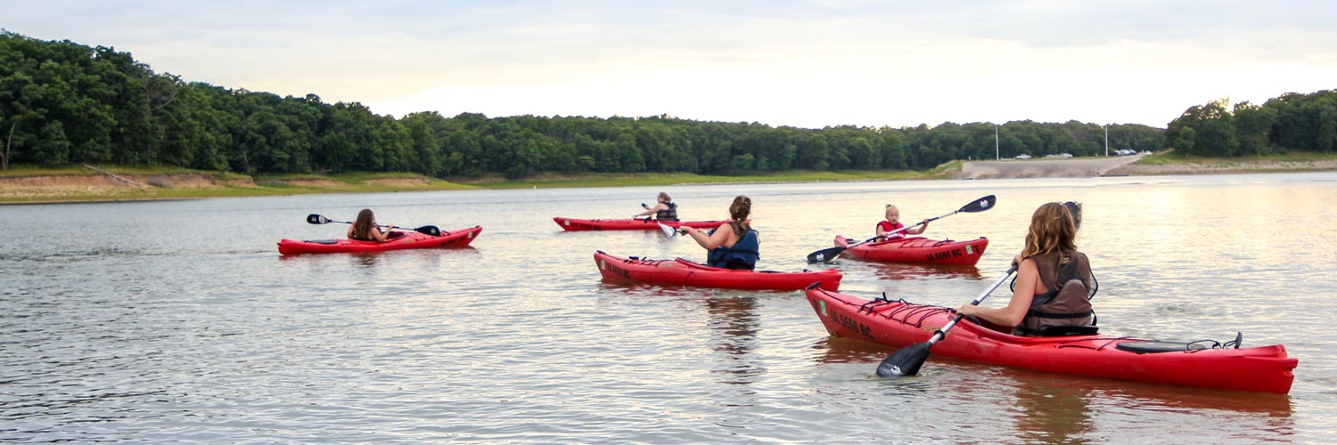 A group of people enjoy kayaking together on Rathbun Lake at Honey Creek Resort